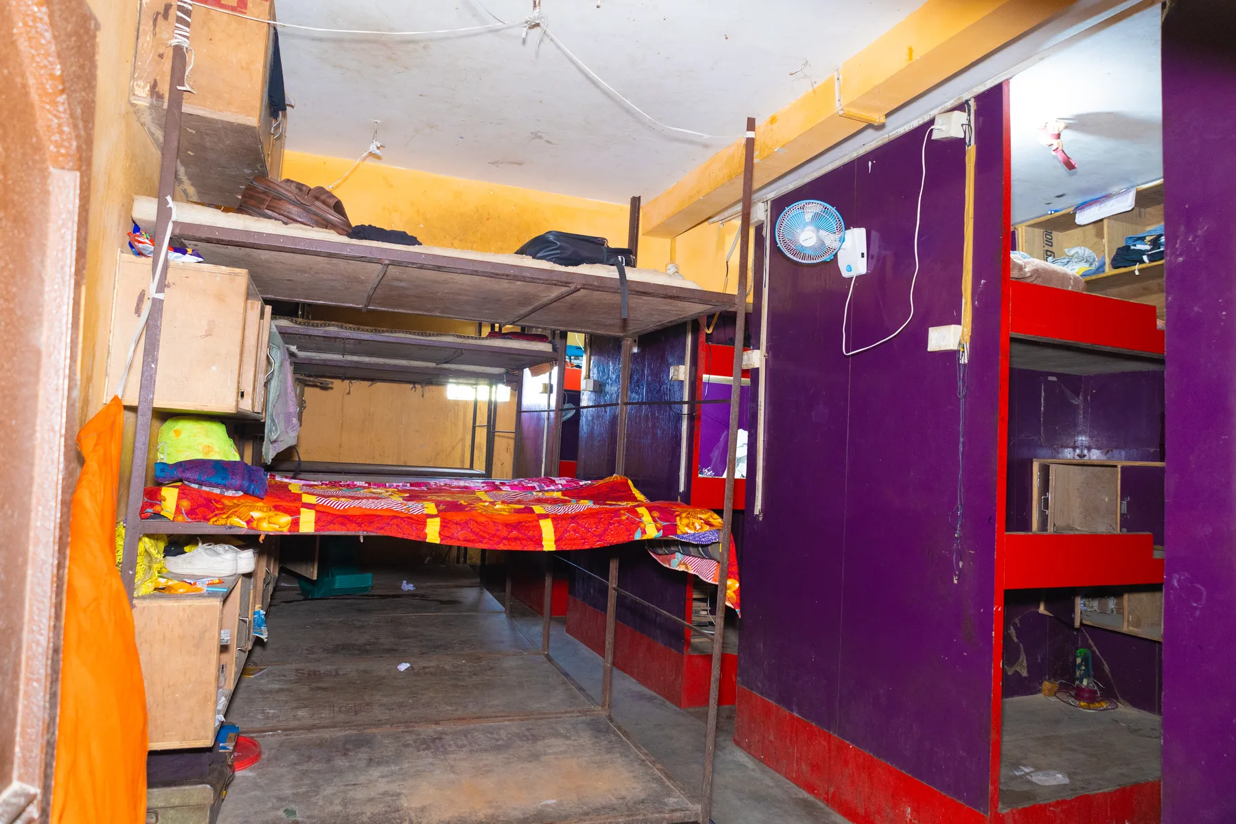A hostel dormitory with bunks made up for the day