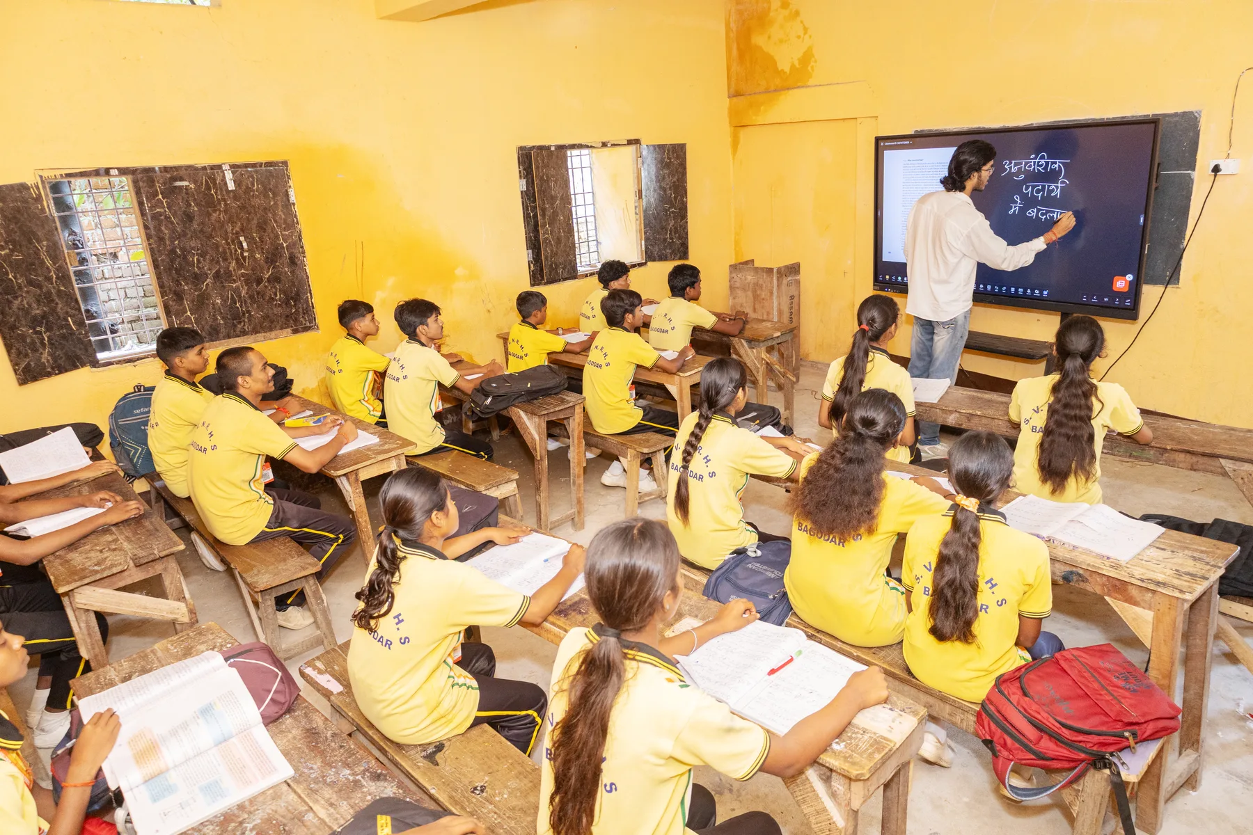 A teacher writing on the interactive board